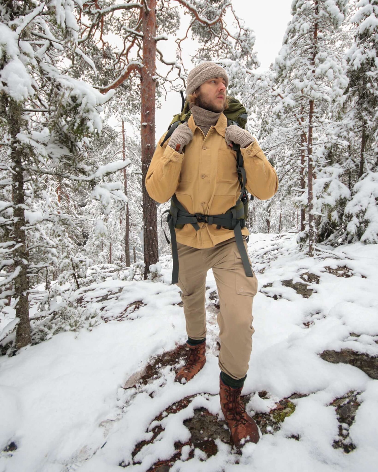 Mies kävelee talvisessa metsässä